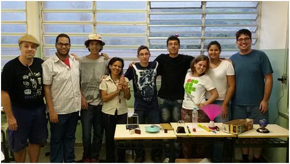 Professores Ricardo e Carla, bolsistas do IFSP e aluno Gabriel Santos na sala com a oficina de experimentos científicos