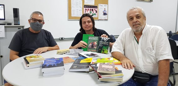 Imagem 1 - Marcio, Rodrigo e Ricardo com os livros doados na biblioteca