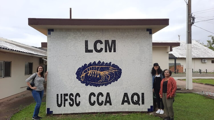 Professoras Samara e Silvete, e aluna Victória em frente ao laboratório da UFSC