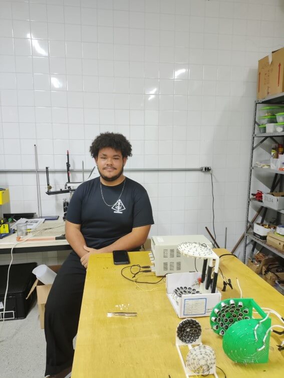 Imagem 7 – Licenciando Caio Nicolas junto ao experimento de levitação acústica